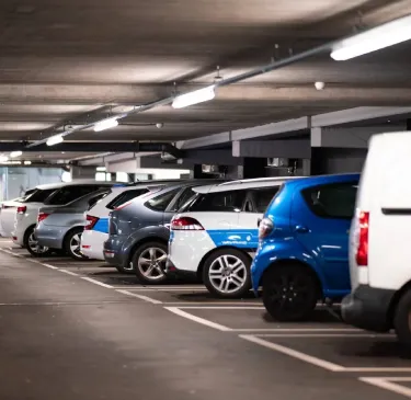 Autos estacionados en fila dentro de un estacionamiento subterráneo.