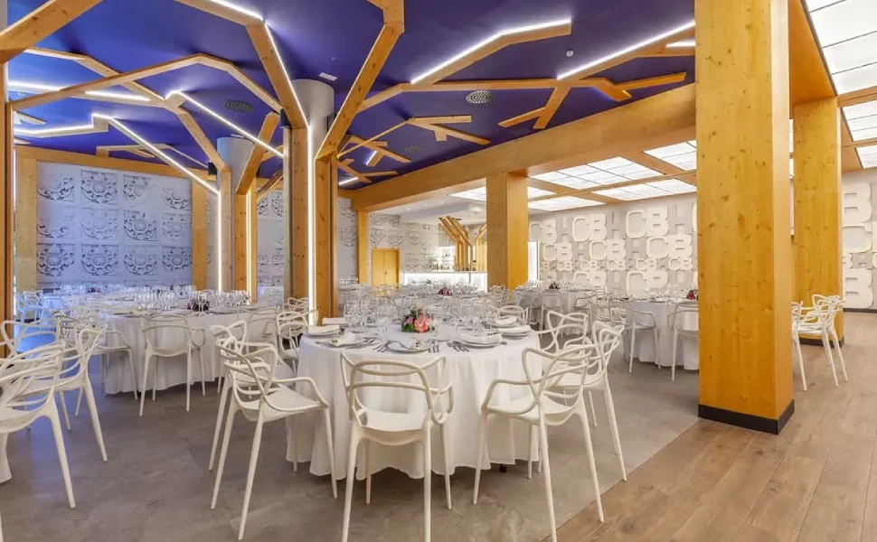 Comedor elegante con mesas redondas y techo decorado con luces.