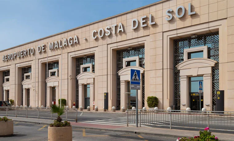 Fachada del Aeropuerto de Málaga-Costa del Sol con señal de cruce peatonal.