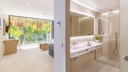 Habitación moderna con baño integrado, vistas al exterior y decoración minimalista.