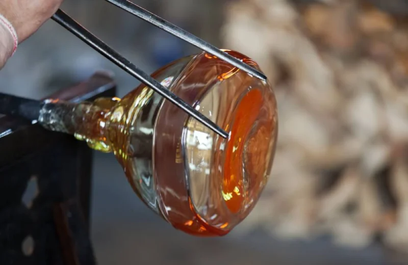 Proceso de soplado de vidrio en caliente moldeado con pinzas.