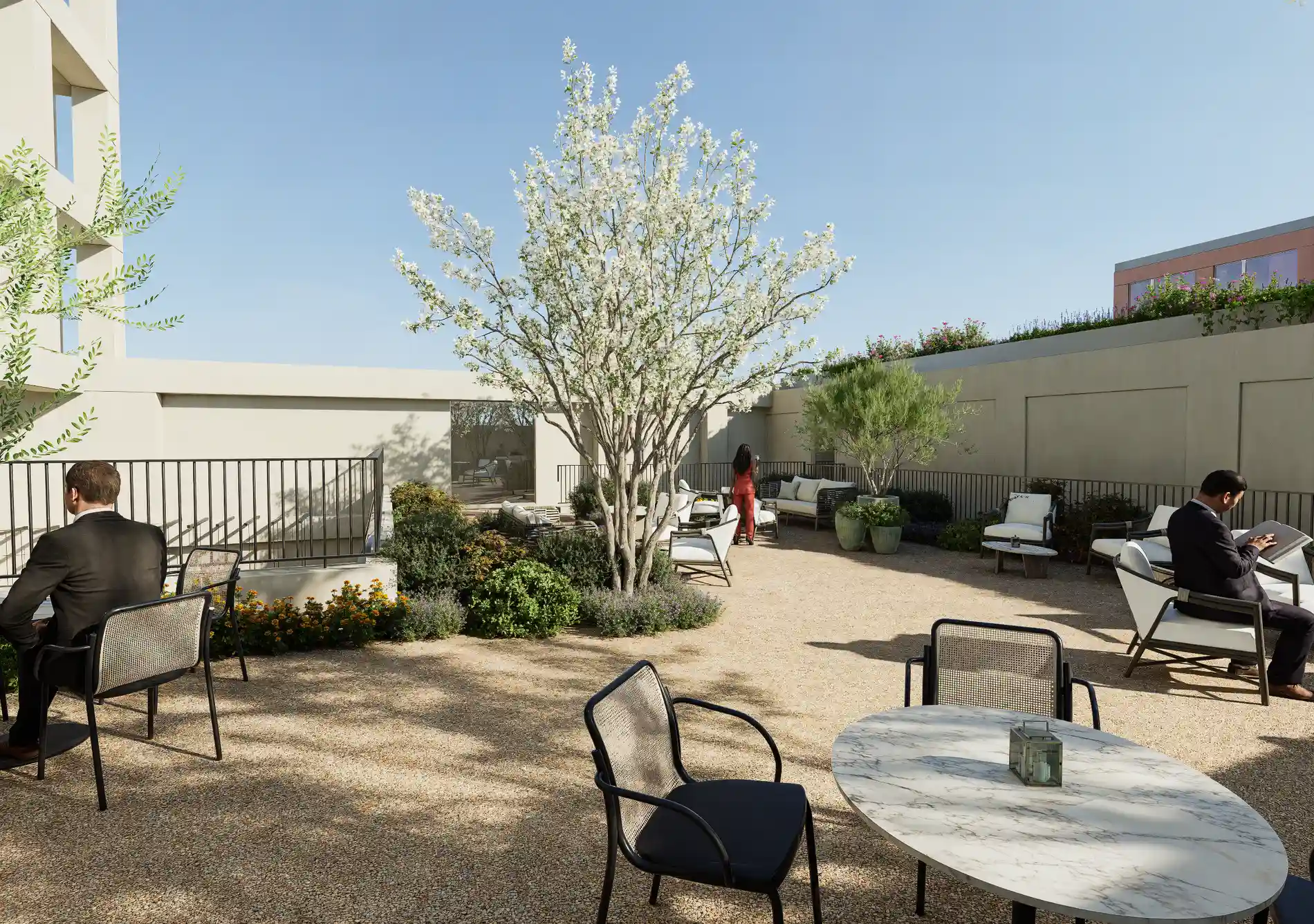 Rooftop garden with seating, trees, and people relaxing under a clear blue sky.