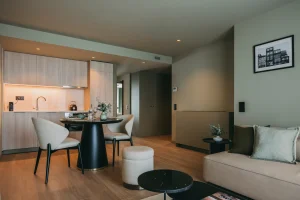 Modern apartment interior with kitchen, dining table, and cozy seating area.