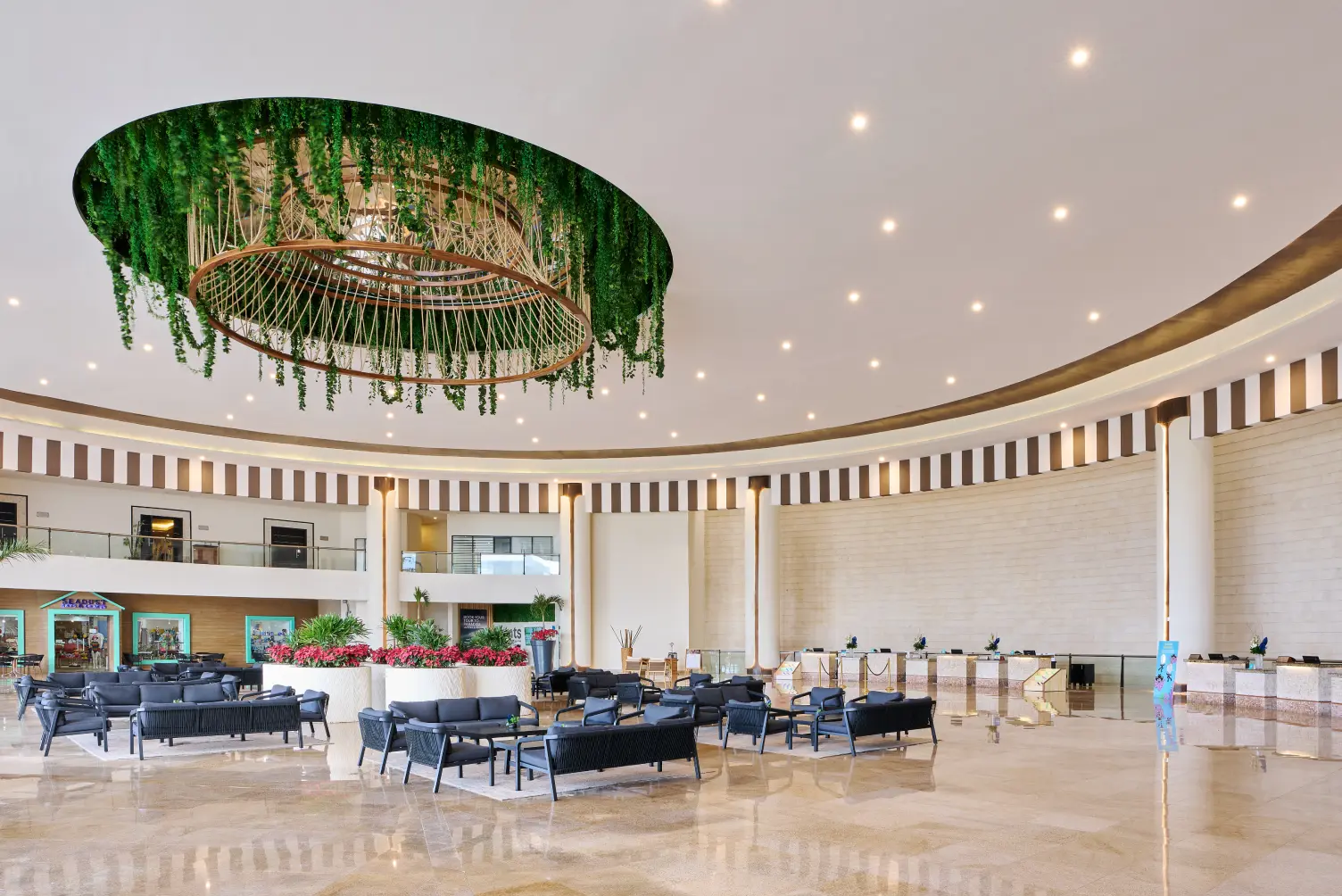 Spacious modern lobby with a green chandelier, seating area, and striped columns.