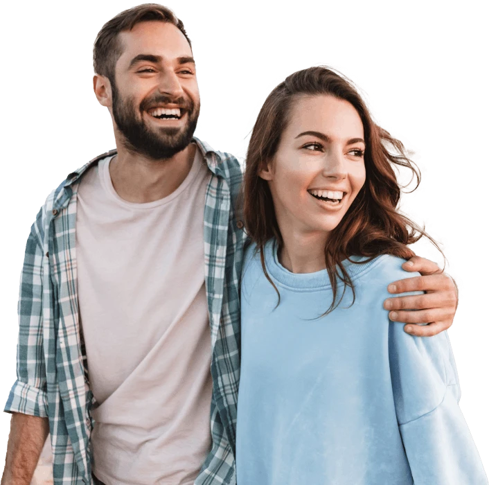 Pareja sonriendo y abrazándose; el hombre lleva camisa a cuadros y la mujer un suéter azul.