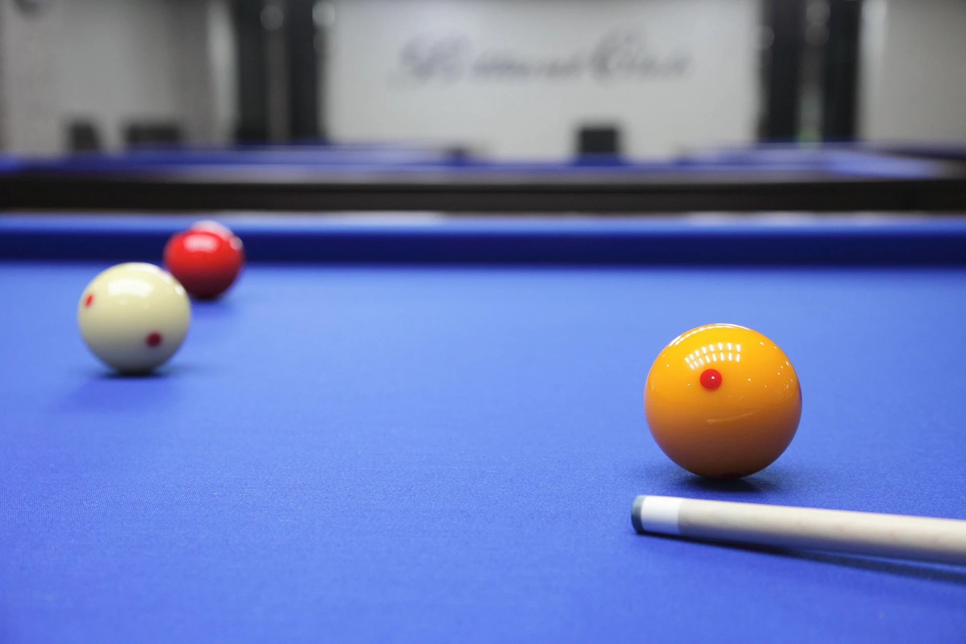 Billiard balls and cue on a blue table.
