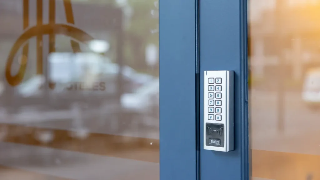 Teclado numérico en una puerta azul con lector de tarjetas RFID.