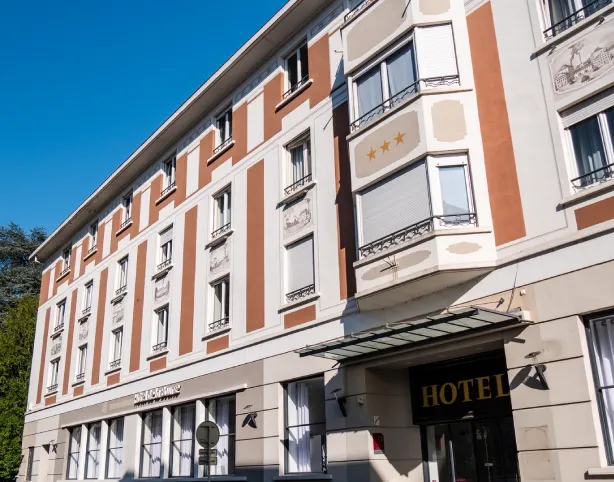Hôtel à façade classique avec trois étoiles sur un fond bleu.