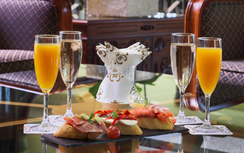 Cuatro bebidas y aperitivos sobre una mesa con un elegante fondo.