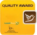 Yellow "Quality Award" plaque with bird logo and "LuxairTours" text.