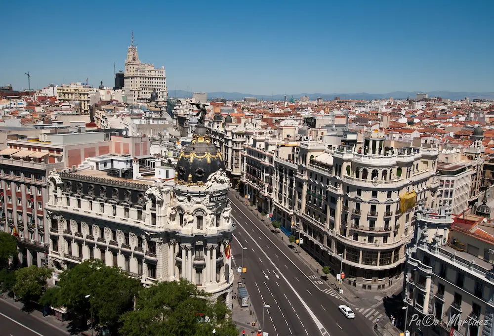 Vista aérea de un cruce de calles en Madrid con arquitectura clásica y cielo despejado.
