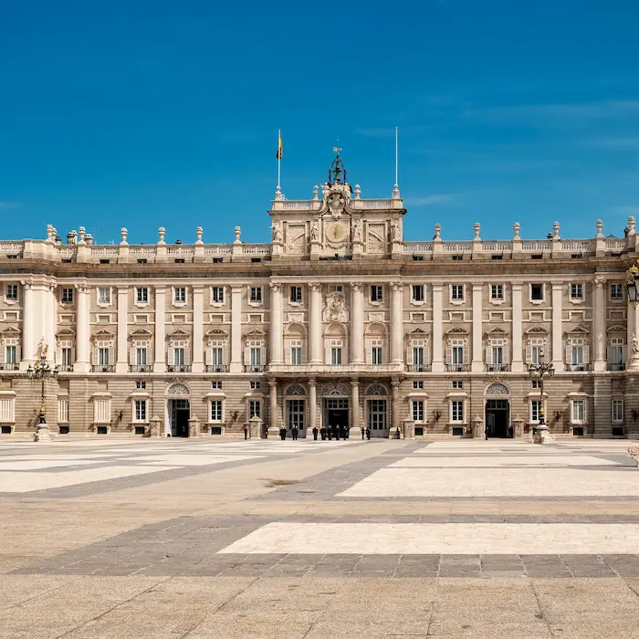 Palacio Real de Madrid con cielo azul y plaza delantera amplia y despejada.