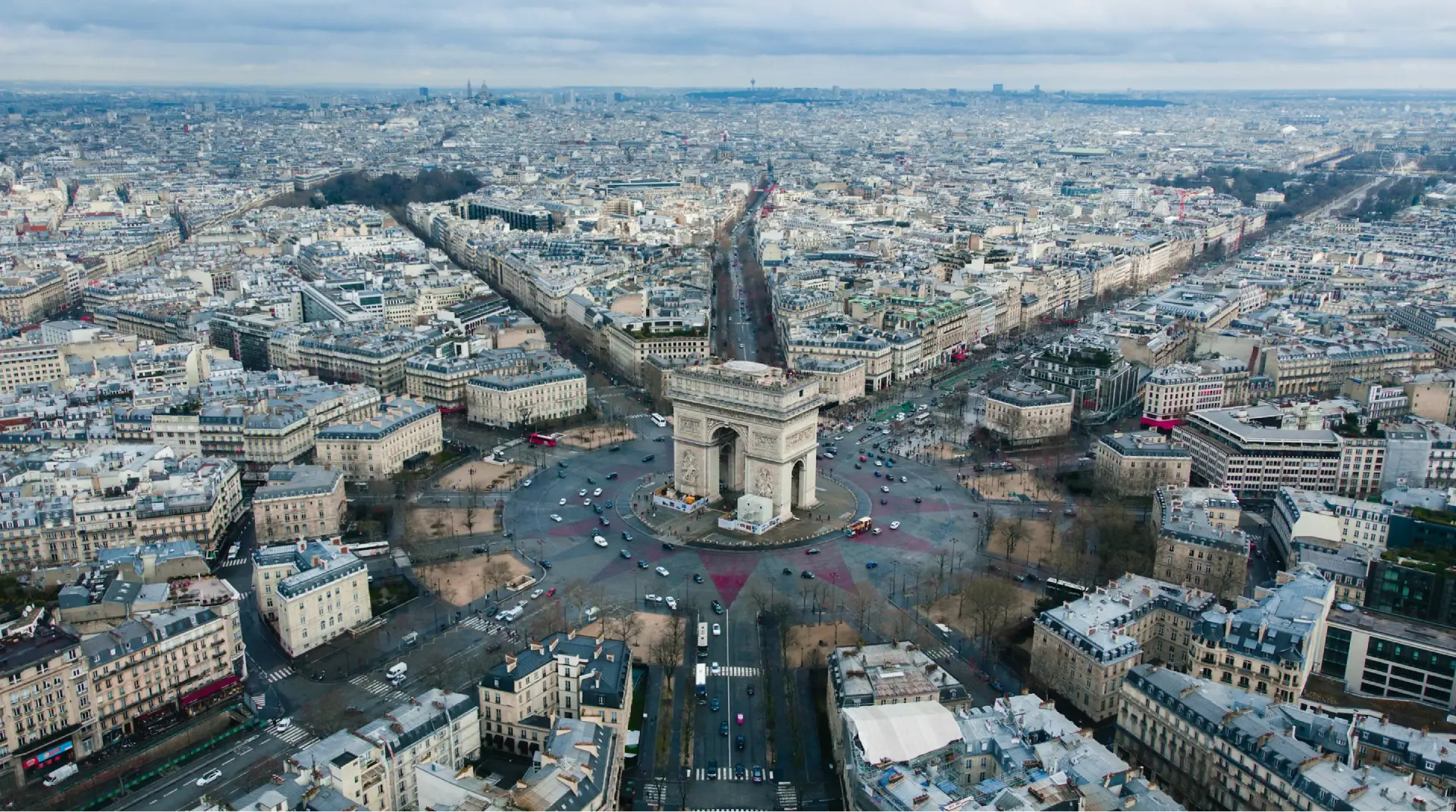 Vue aérienne de l'Arc de Triomphe entouré de rues rayonnantes à Paris.