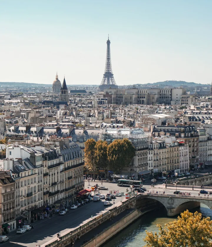 Vue de Paris avec la tour Eiffel en arrière-plan et la Seine au premier plan.