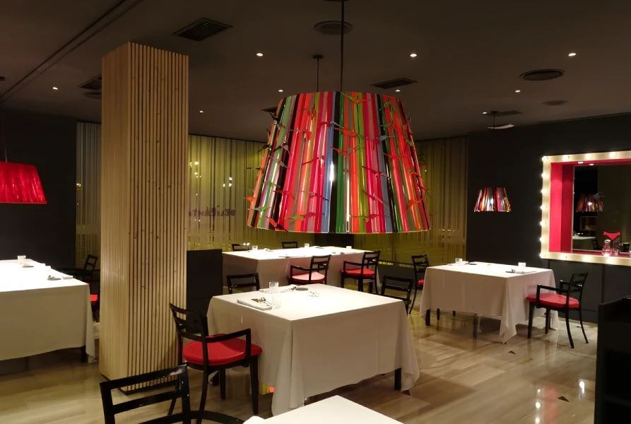 Un restaurante elegante con lámparas de colores y mesas con manteles blancos.