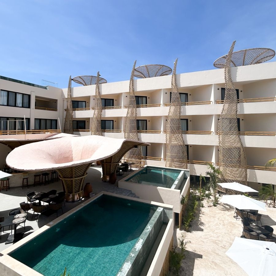 Hotel courtyard with pools, lounge chairs, and unique architectural features.