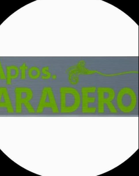 La imagen muestra un letrero gris con texto verde que dice "Aptos. ARADERO".