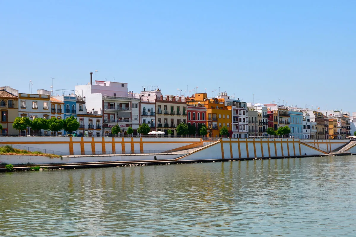 Viviendas coloridas frente a un río bajo un cielo despejado.