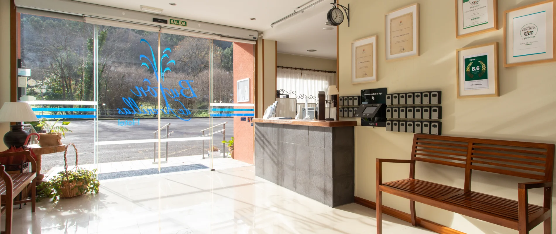 Recepci&oacute;n de un hotel con vista exterior y cuadros en la pared.