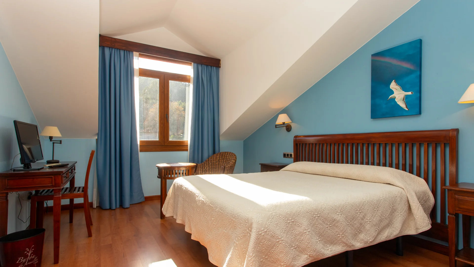Habitaci&oacute;n con cama, escritorio, ventana y paredes azul claro. Decoraci&oacute;n minimalista y acogedora.
