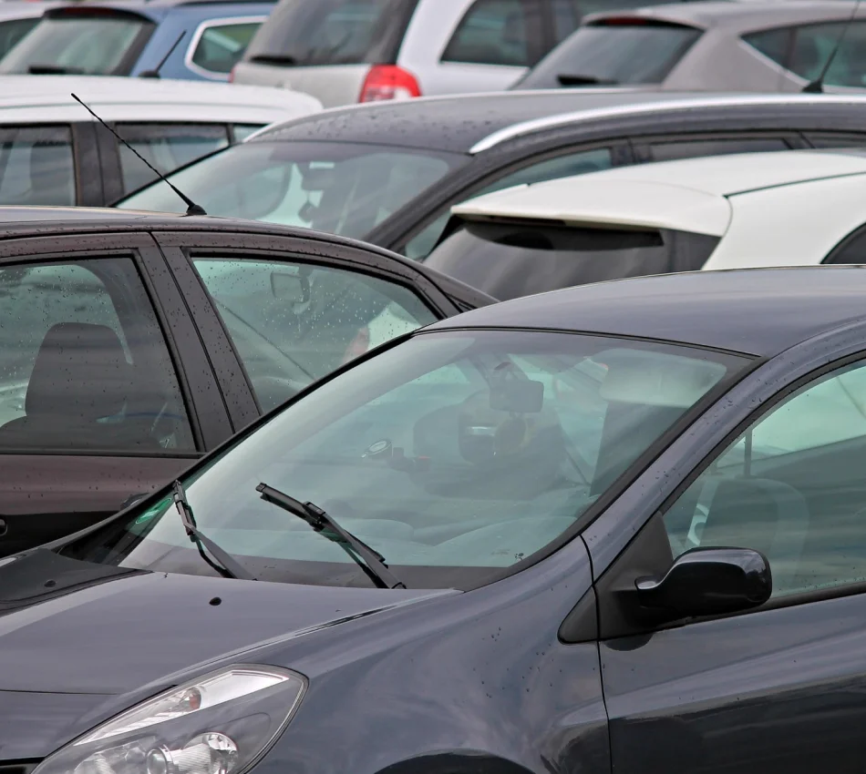 Varios autos estacionados en un aparcamiento al aire libre.