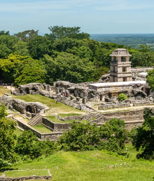 Ruinas mayas en medio de la selva, con una estructura de torres y piedra antigua.