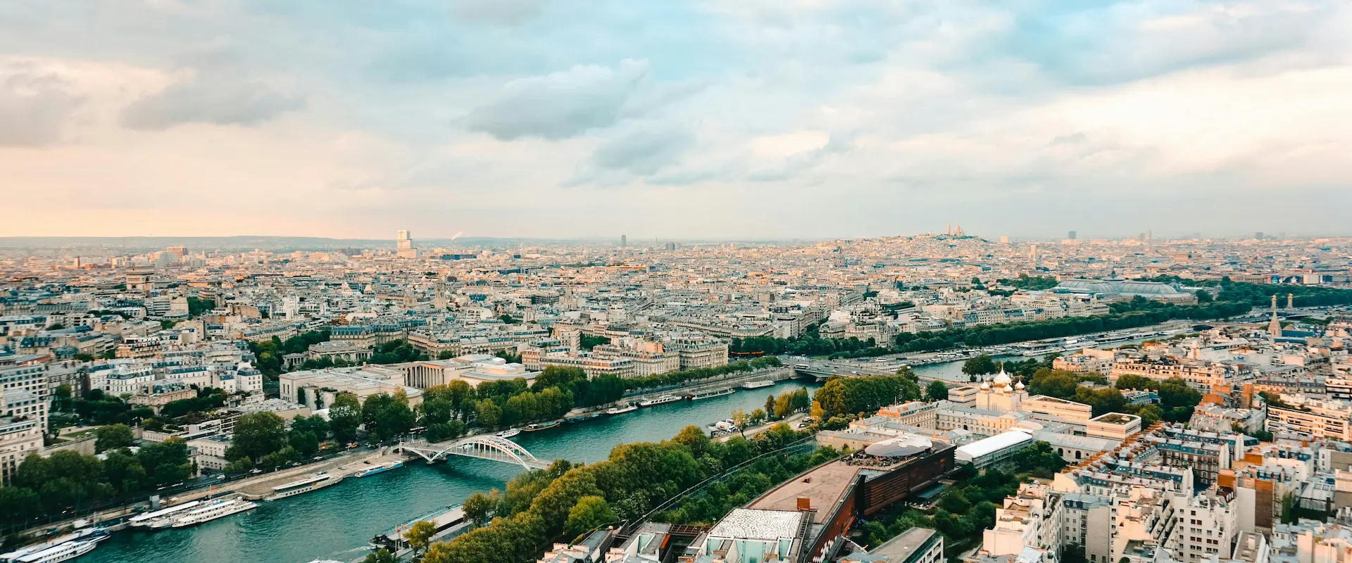 Vue aérienne de Paris avec la Seine traversant la ville et des bâtiments en contrebas.