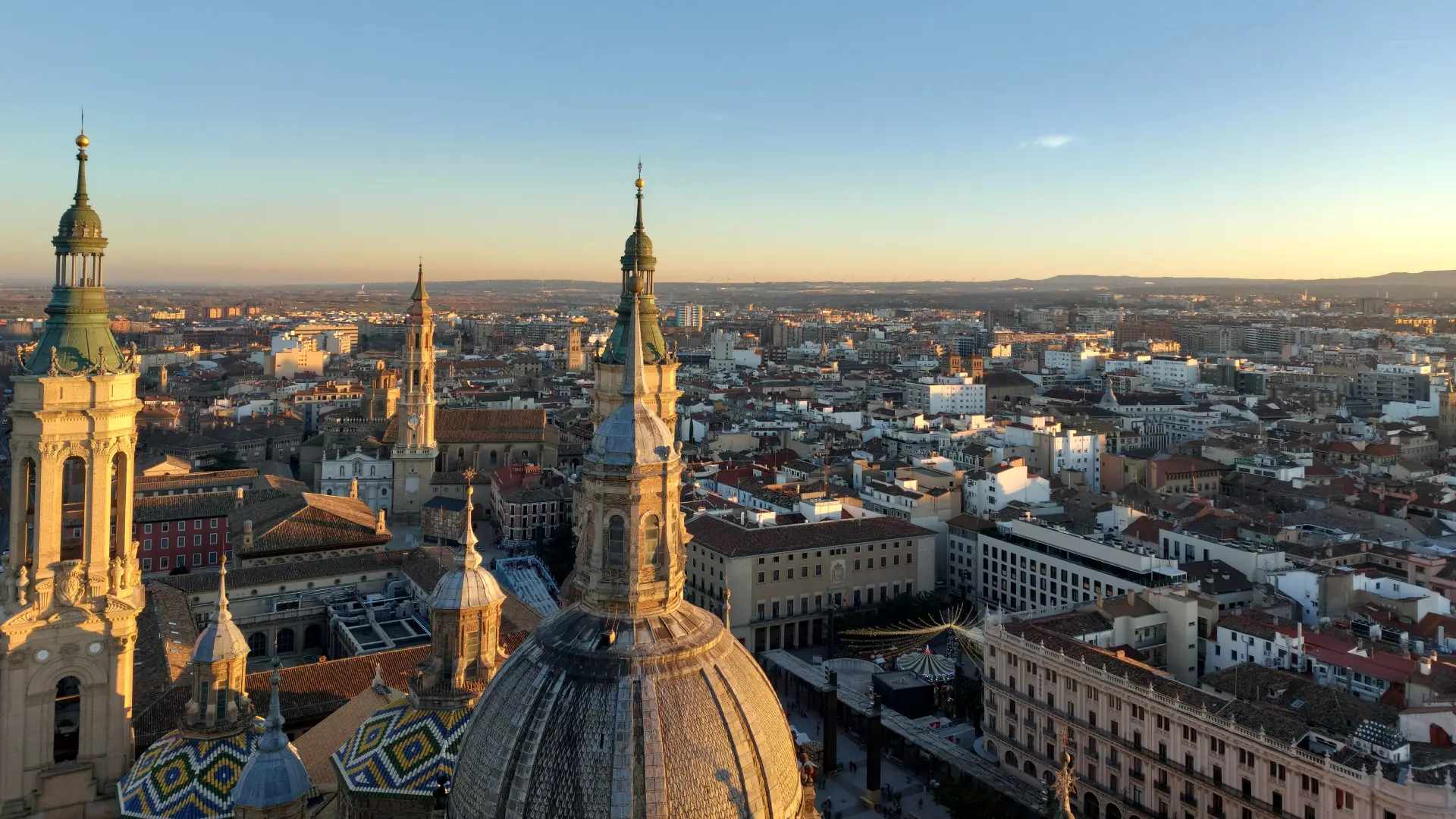 Vista panor&aacute;mica de una ciudad al atardecer con una catedral y edificios hist&oacute;ricos destacados.