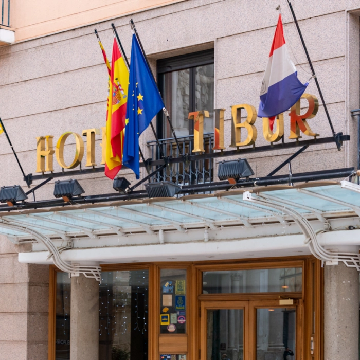 Edificio del Hotel Tibur con banderas en la fachada y letrero dorado en Zaragoza.