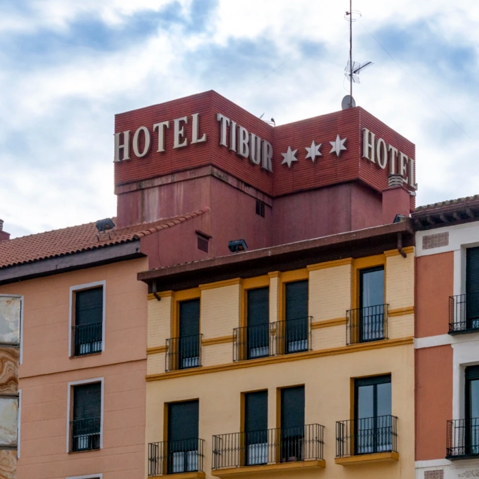 Edificio del Hotel Tibur con un letrero de tres estrellas en lo alto, cielo nublado de fondo.