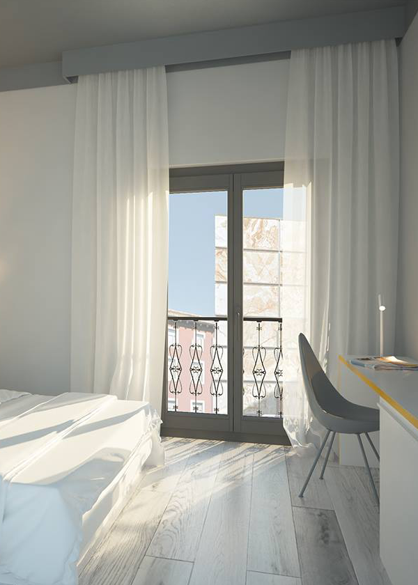 Habitaci&oacute;n luminosa con cama, escritorio y ventana con cortinas blancas.