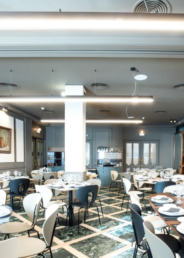 Restaurante elegante con mesas y sillas modernas y suelo de m&aacute;rmol.
