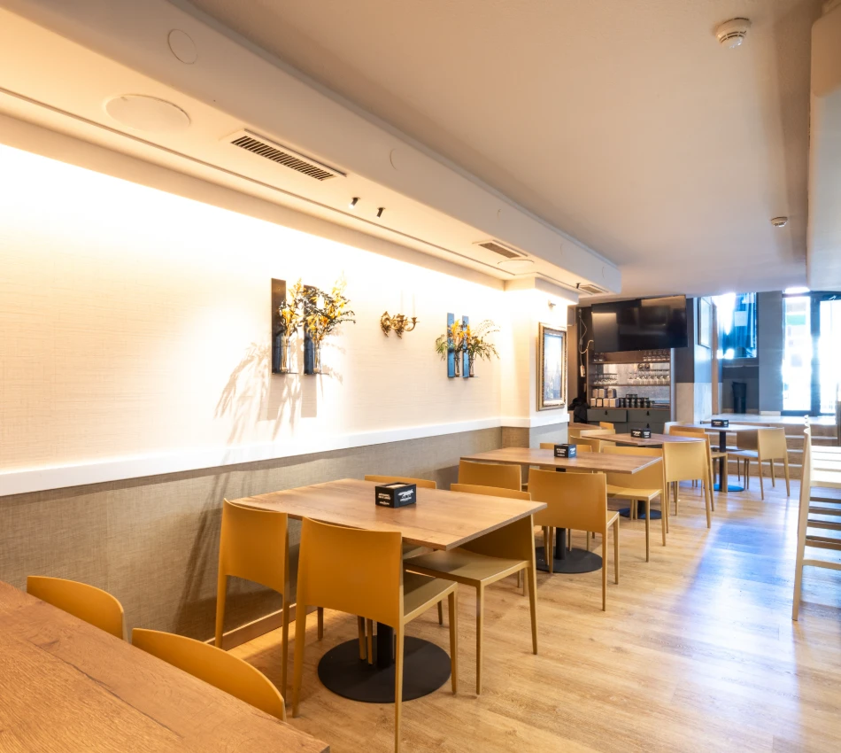 Comedor moderno con sillas amarillas y mesas de madera.