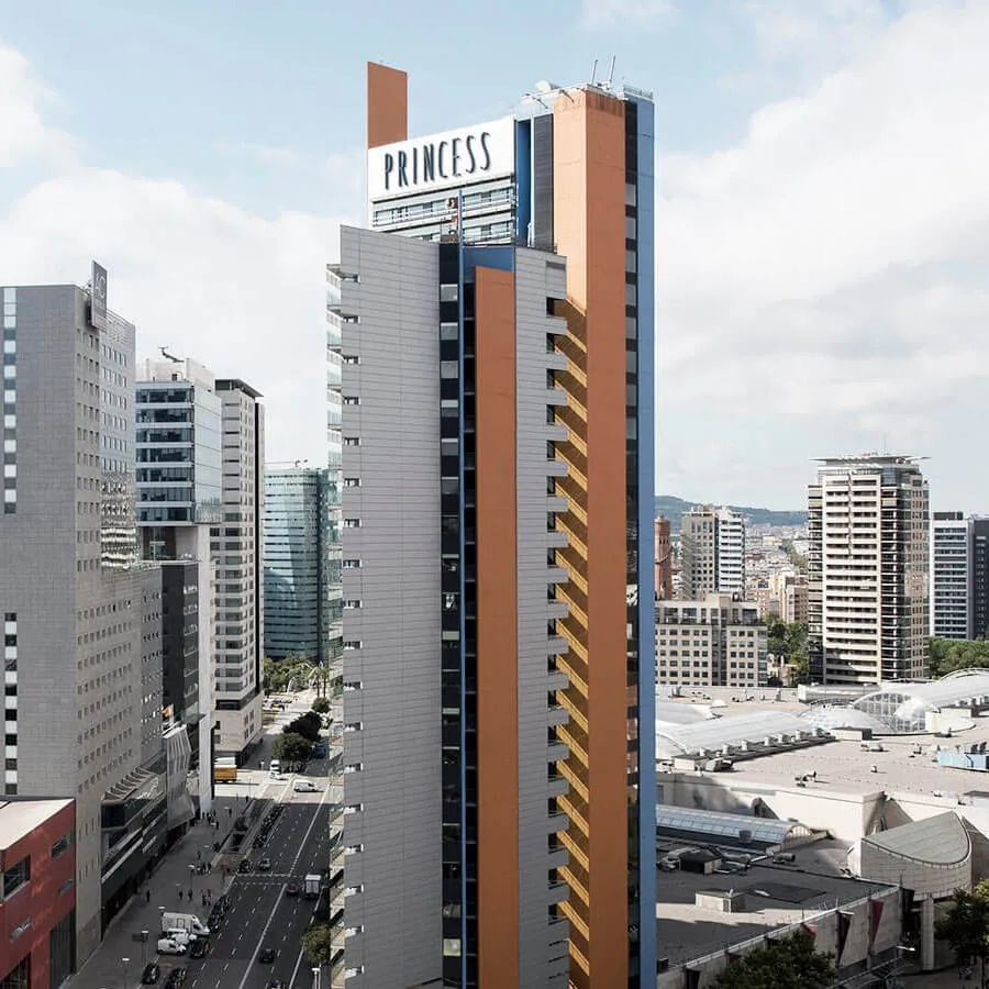 Rascacielos "Princess" en un entorno urbano moderno, rodeado de otros edificios altos y una calle transitada abajo.