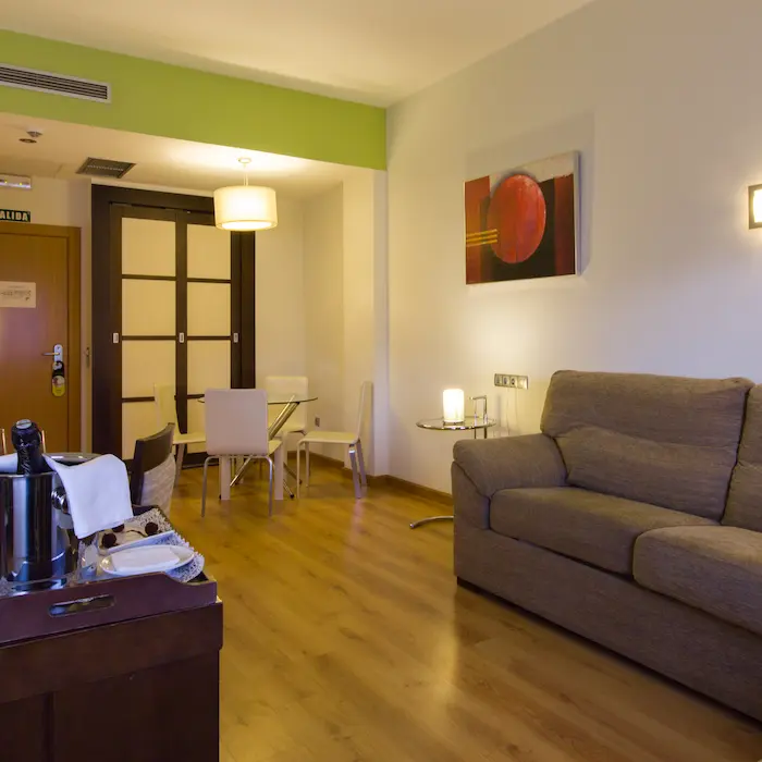 Sala moderna con sofá, mesa de comedor y decoración minimalista en tonos cálidos.