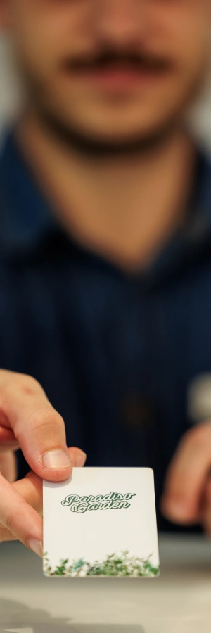 Persona mostrando una tarjeta escrita, fondo difuminado.