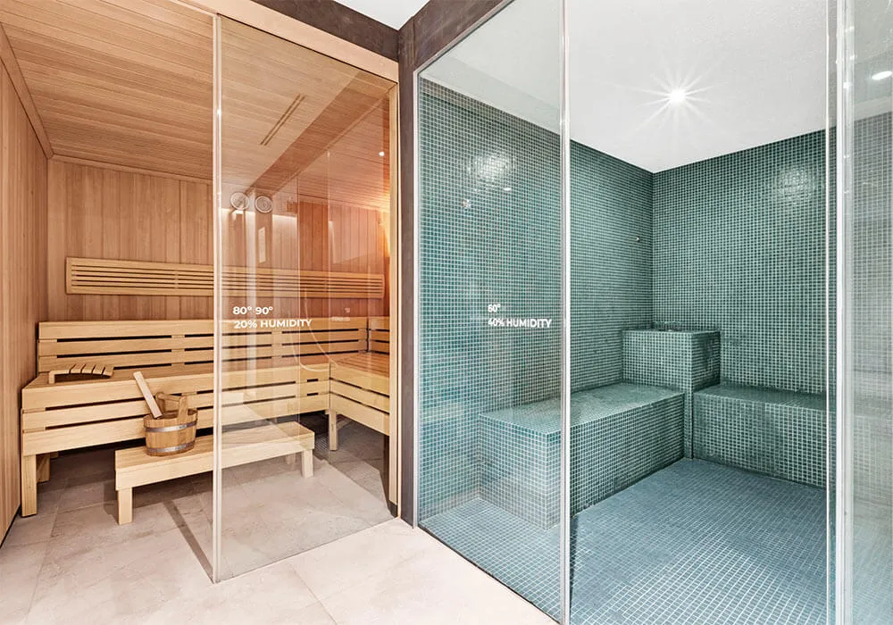 Dos salas adyacentes: sauna de madera y baño de vapor de azulejos verdes.