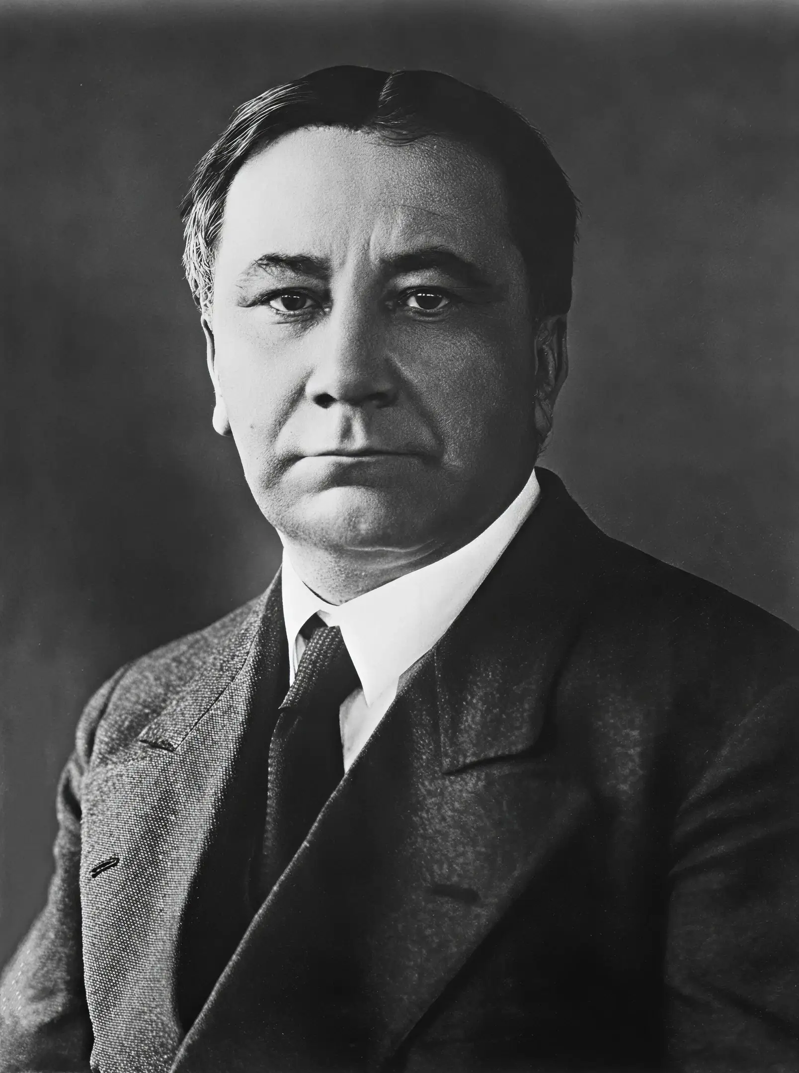 Portrait of a serious man in a suit and tie, black and white photograph.
