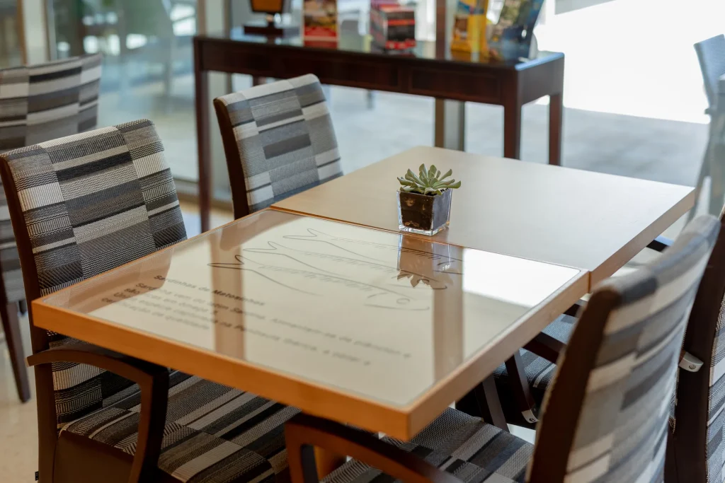 Dining table with striped chairs and a small succulent plant centerpiece.