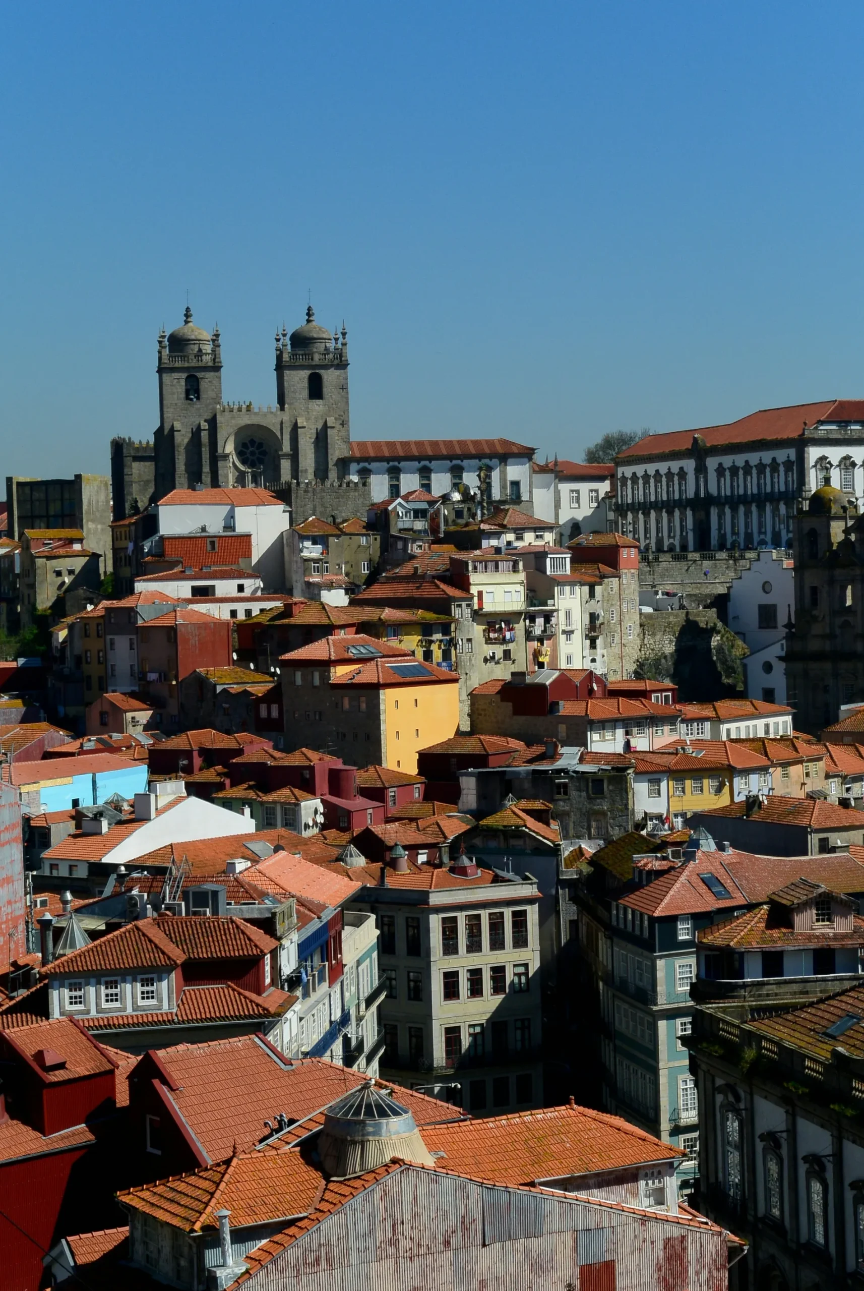 Aerial view of colorful rooftops and historic buildings under a clear blue sky.