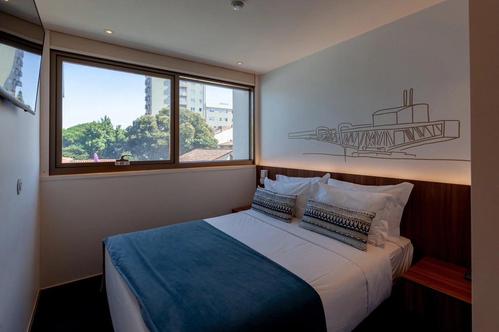 Small modern bedroom with a window view and wall art above the bed.