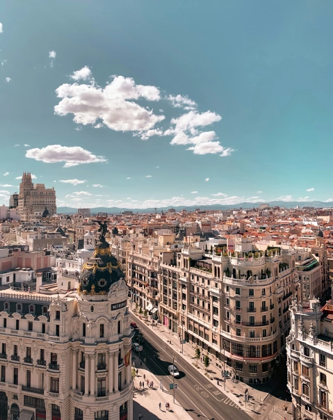 Vista aérea de una ciudad con edificios históricos y un cielo despejado con nubes dispersas.