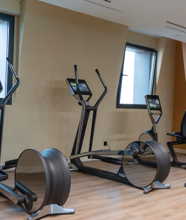 M&aacute;quinas de ejercicio en un gimnasio moderno y bien iluminado.