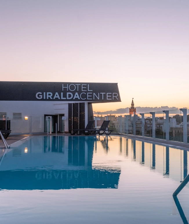 Piscina en la azotea del Hotel Giralda Center al atardecer.