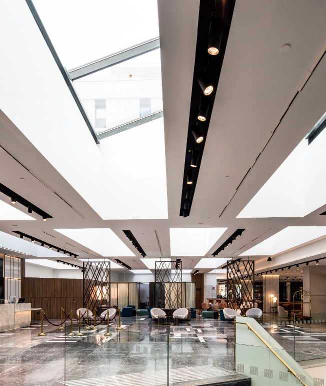 Lobby moderno con techo de cristal y luces empotradas en el techo.