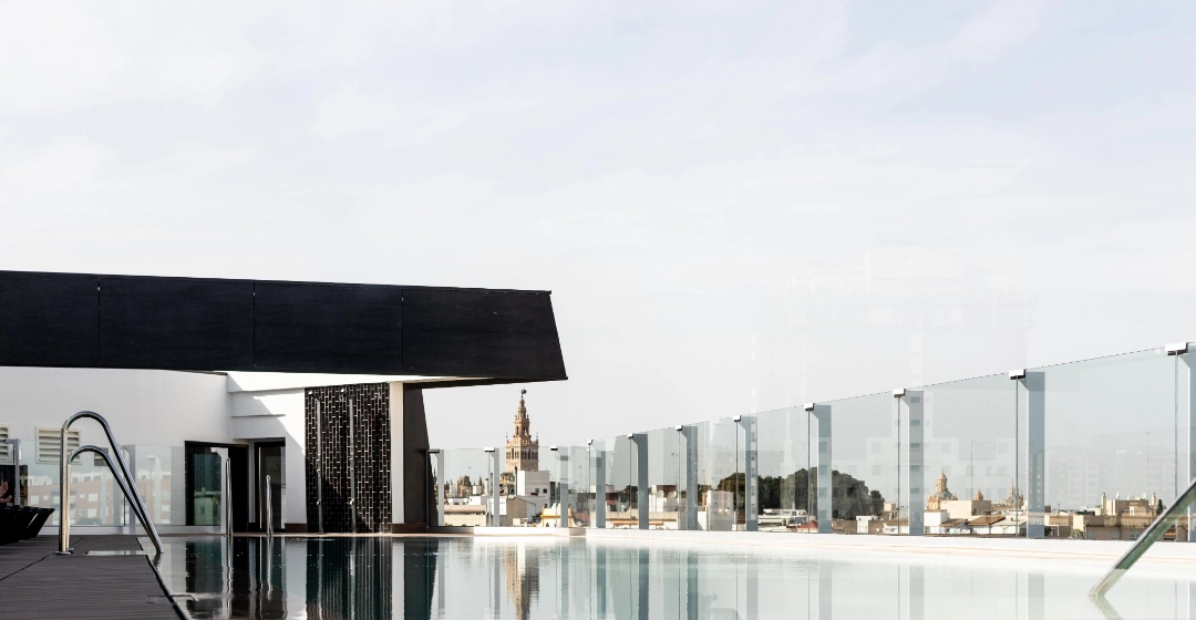 Piscina en la azotea con vista urbana y cielo despejado.