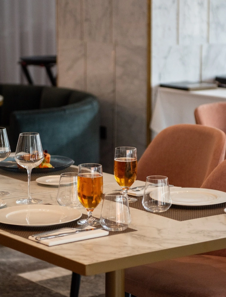 Mesa elegante con copas y platos en restaurante moderno.