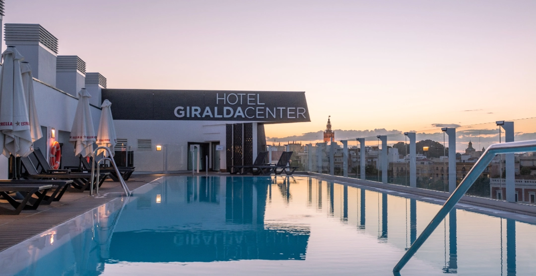 Piscina en la azotea del Hotel Giralda Center al atardecer.