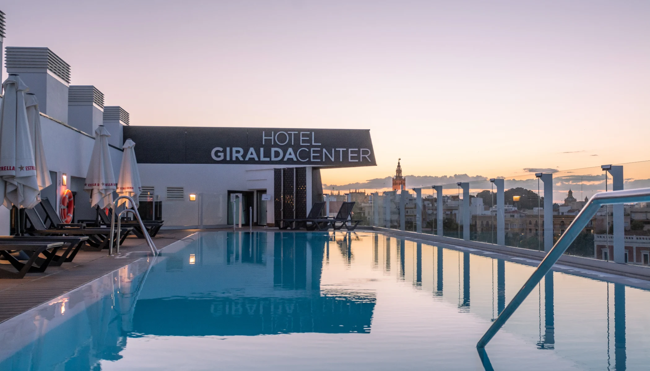 Piscina en la azotea del Hotel Giralda Center al atardecer.