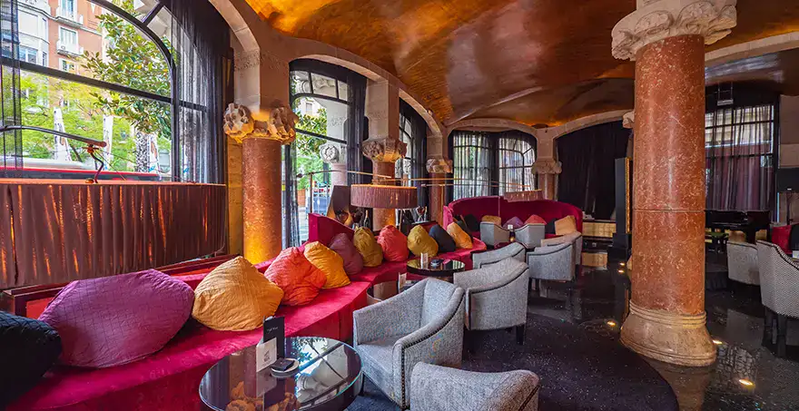 Sal&oacute;n elegante con sof&aacute;s coloridos y decoraci&oacute;n arquitect&oacute;nica cl&aacute;sica.